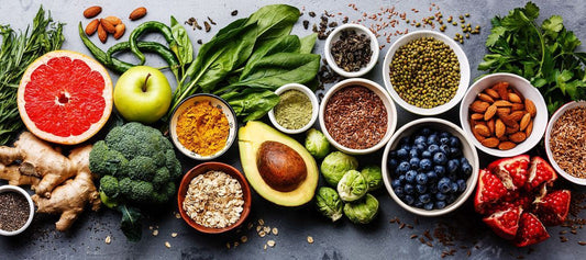 An overhead view of natural ingredients like avocado, blueberries, almonds, and turmeric, showcasing the types of pure, nutrient-rich sources found in motherdaily supplements.